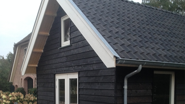 Binnenzijde van het tuinhuis met houten balken en zolder in tuinhuis in Epe