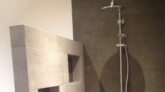 Detail van de badkamer met regendouche en opbergvakken in de muur Detail van de badkamer met regendouche