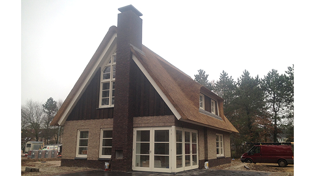 Woning met rieten kap in Ermelo. Van den Berg, Bouwveluwe Zijaanzicht op de woning met rieten kap in Ermelo. Opvallend is de grote schoorsteen in contrasterend bruine stenen